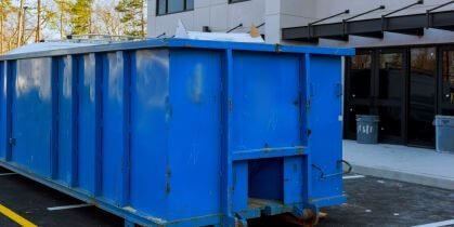 Blue dumpster in front of building.