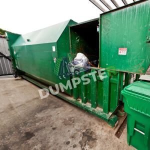 A green dumpster with a matching green lid, sitting in a clean outdoor area.